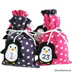 three small bags with penguins on them and one has the number twenty five in it