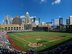 a baseball game in progress with the city skyline in the background