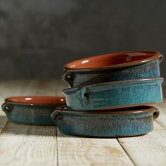 three blue and orange dishes stacked on top of each other, with one bowl in the middle