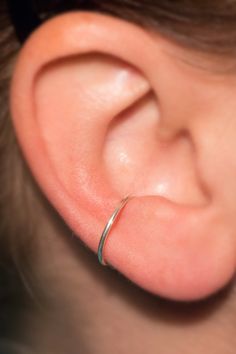 a close up of a person's ear with a ring on the end of it