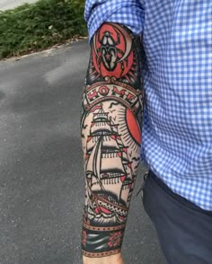 a man's arm with a ship tattoo on it and an octopus in the middle