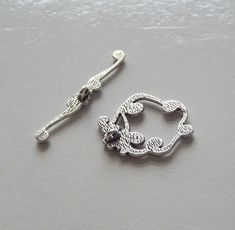 a pair of silver colored earrings sitting on top of a table