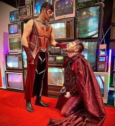 a man getting his hair cut by a mannequin in front of televisions