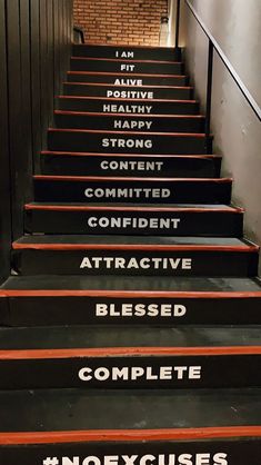 a set of stairs with different words written on the treading and handrails