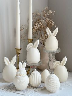 some white candles are sitting on a table