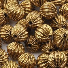 many shiny gold colored beads on a white surface