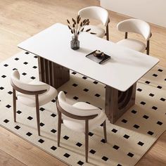 a white table with four chairs and a vase on top of it in the middle of a room