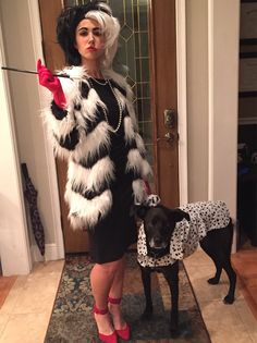 a woman standing next to a black dog wearing a white and black dress with red heels