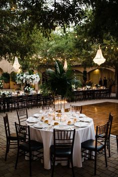 an outdoor dining area with tables and chairs set up for a formal function in the evening