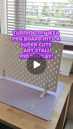 a desk with a computer on it and the words turning my ikea peg board into a super cute art stall pin display