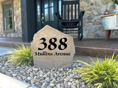 a large rock sitting in front of a house with the number 6006 on it