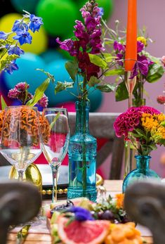 the table is set with colorful flowers and wine glasses