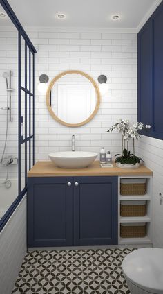 a bathroom with blue cabinets and a round mirror