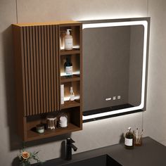 a bathroom vanity with lighted mirror above it and bottles on the counter top next to it