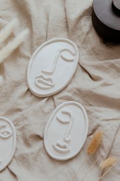 three cookie cutters sitting on top of a sheet of paper next to some dried grass