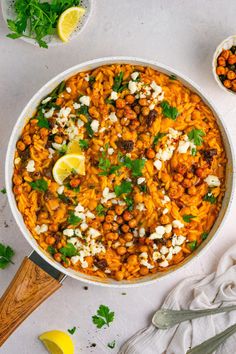 a large pot filled with food next to some lemon wedges and cilantro