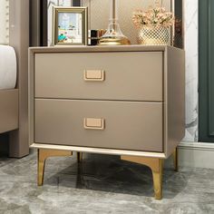 a white chest of drawers with gold handles and knobs on top in a living room