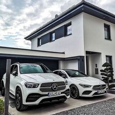 two mercedes benz cars parked in front of a house