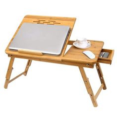 a laptop computer sitting on top of a wooden folding table with a tray underneath it