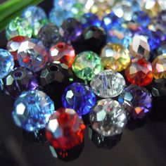 many different colored diamonds are on the table next to a green plant with long stems