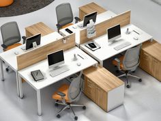 an office cubicle with multiple desks and chairs