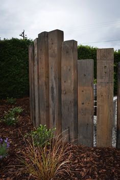 the wooden posts are lined up next to each other in the dirt and mulch