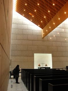 the interior of a church with rows of pews and lights hanging from the ceiling