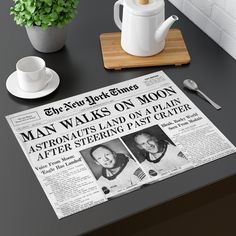 a newspaper sitting on top of a table next to a cup