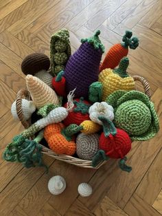 a basket filled with crocheted vegetables sitting on top of a wooden floor