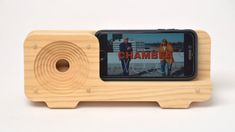 a cell phone sitting on top of a wooden device holder that is made out of wood