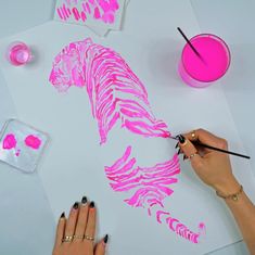 someone is using pink paint to create a tiger design on a piece of white paper