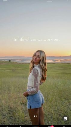 a woman standing in the middle of a field with her hands on her hips and looking at the camera