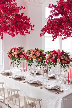 the table is set with pink flowers and candles