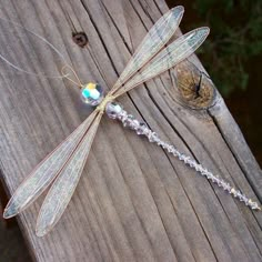 a dragonfly sitting on top of a wooden fence