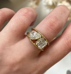 a woman's hand with a gold ring and two diamond rings on her fingers