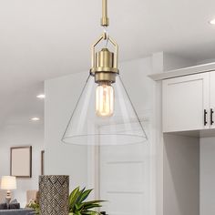 a light that is hanging from a ceiling in a room with white walls and cabinets