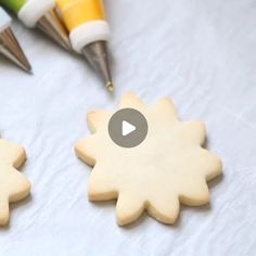 two decorated cookies sitting on top of a table next to crayons and markers