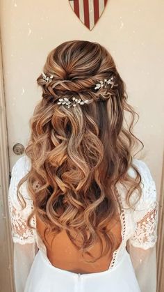 the back of a woman's head with long hair and flowers in her hair