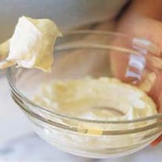 a person is dipping something into a bowl