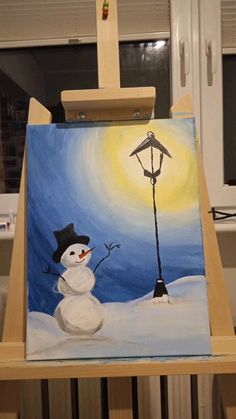 a painting of a snowman on an easel with a lamp post in the background