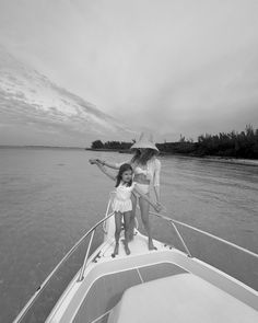 two women are standing on the bow of a boat