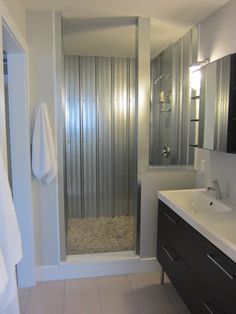 a bathroom with a walk in shower next to a sink