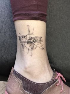 a woman's foot with a small tattoo on the side of her leg and an arrow