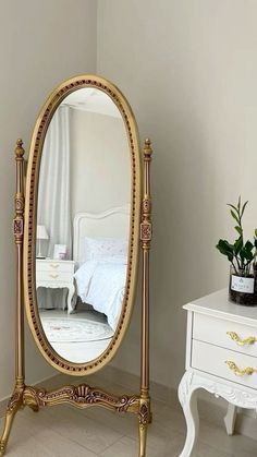 an ornate gold and white dressing table with a large mirror on it's stand