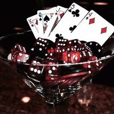 a glass bowl filled with dice and playing cards