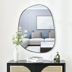 a black and gold sideboard with a mirror above it on the wall behind it