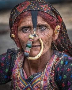 an old woman with piercings on her nose and nose ring in front of her face