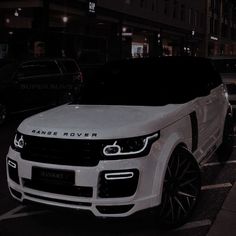 a white range rover parked on the street at night