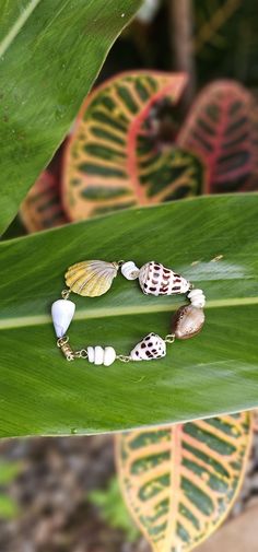 eashell Bracelet Materials: -Seashell from Hawaii - 14K Gold Filled Wire, Staple Chain and Closure About 1 inches Seashell, Shell will vary Packed ready for gift giving Every Jewelry is design and made by me at my home in Lahaina, Hawaii.  I make one jewelry at a time and every style are mindfully hand-crafted at the moment. Some Jewelries will not be re-created and I maintain a unique form. Mahalo for your support! Mother Of Pearl Shell For Vacation, Hand-strung Shell Jewelry For Gifts, Gold Shell Beaded Strand Bracelets, Gold Shell Strand Bracelets, Adjustable Hand-strung Shell Necklace Gift, Gold Shell Bracelet, Hawaiian Shell Jewelry, Ocean-inspired Shell Bracelet Jewelry, Handmade Gold Shell-shaped Bracelet