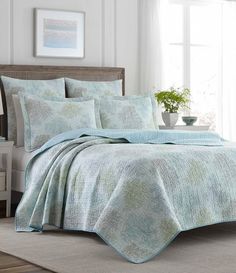 a bed covered in a blue and green bedspread